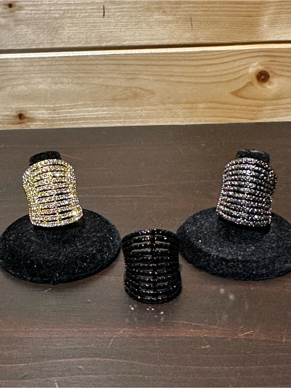 Set of 3 costume jewelry rhinestone rings in gold, slate silver, and black.
